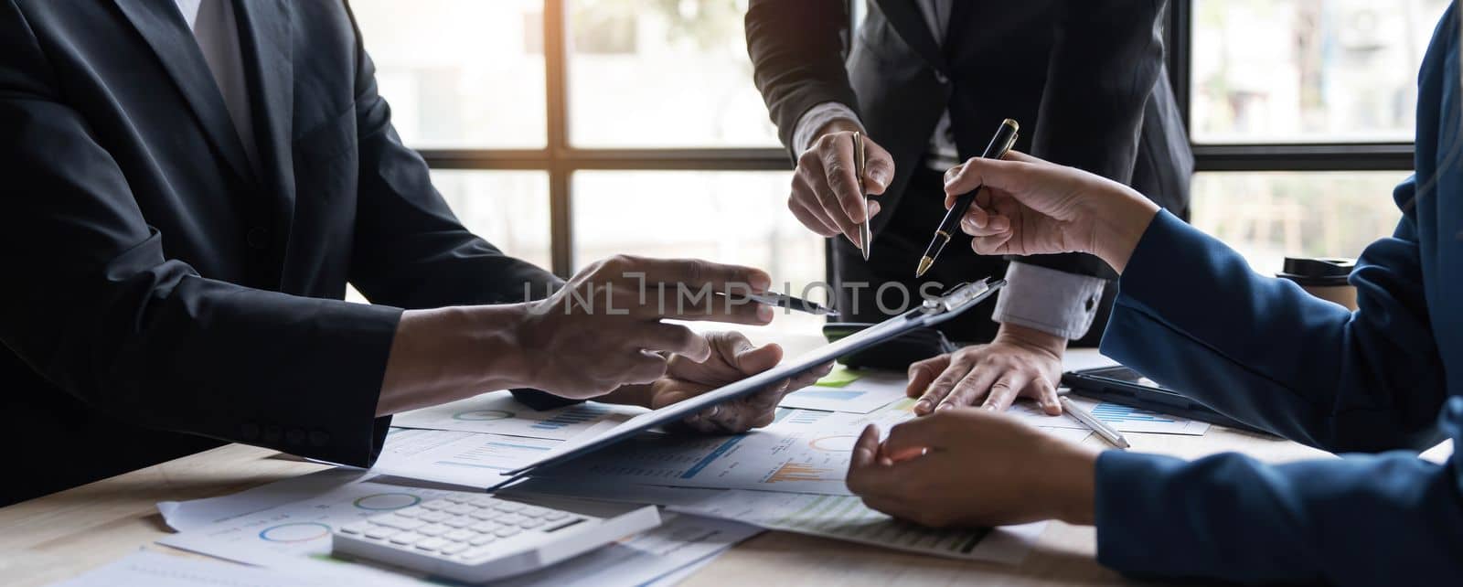 Business People Meeting using laptop computer,calculator,notebook,stock market chart paper for analysis Plans to improve quality next month. Conference Discussion Corporate Concept...