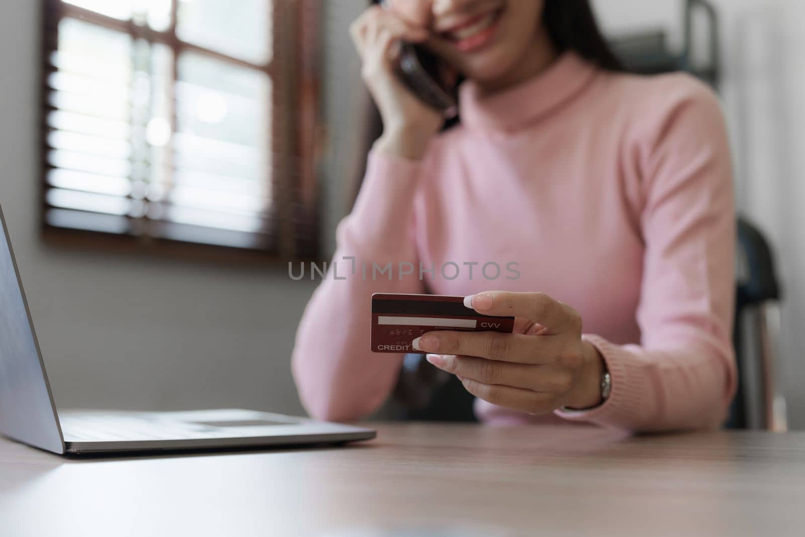 Young person using credit card and laptop computer. Online shopping, e-commerce concept by itchaznong