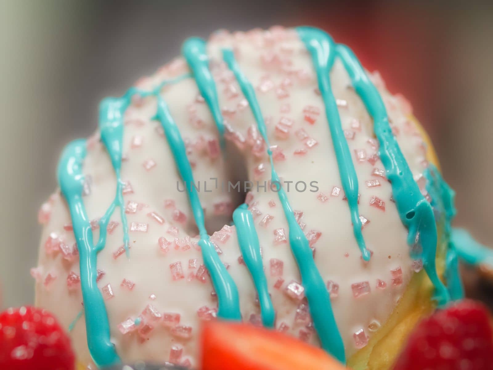 pastry chef cake designer decorating turquoise blue white frosted cheesecake in kitchen with piping bag