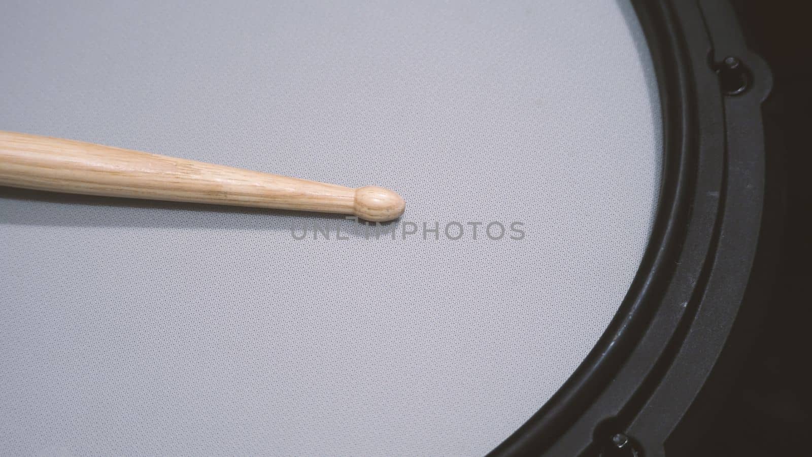 Close-up images of drumsticks on electronic drum snare pad  by gnepphoto