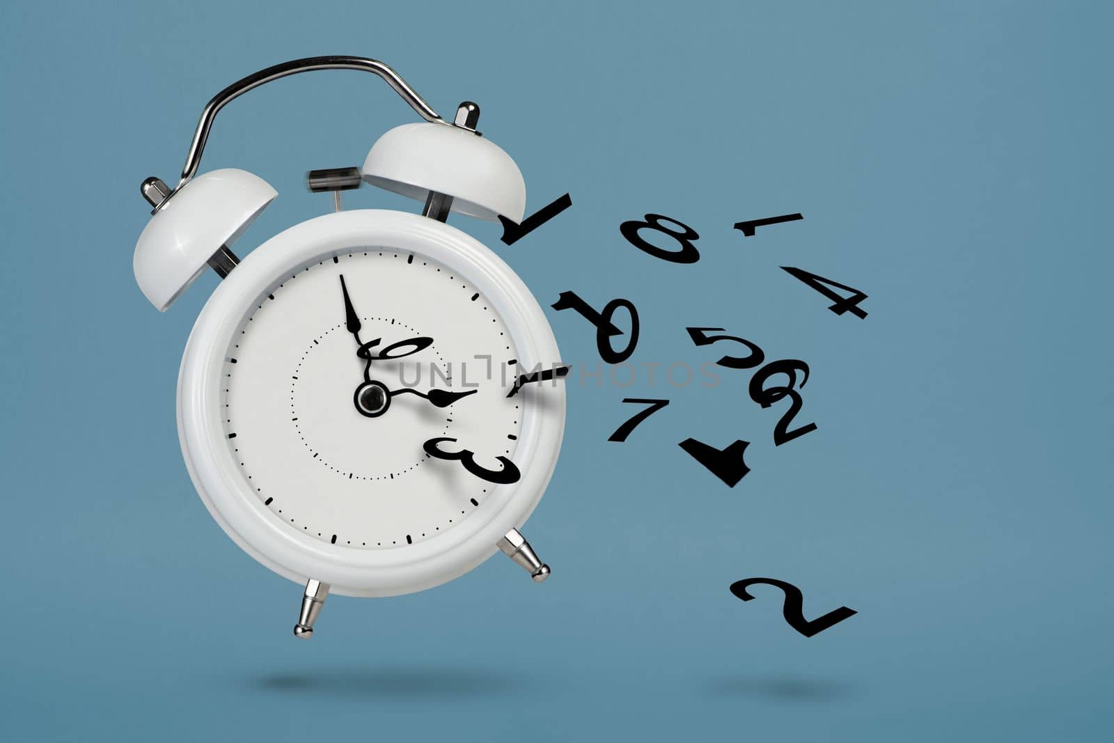 Time is running out. White alarm clock with flying numbers as a symbol of lost time. The concept of time is running out, loss or lack of time, an alarm clock with numbers shatters into small pieces. by SERSOL