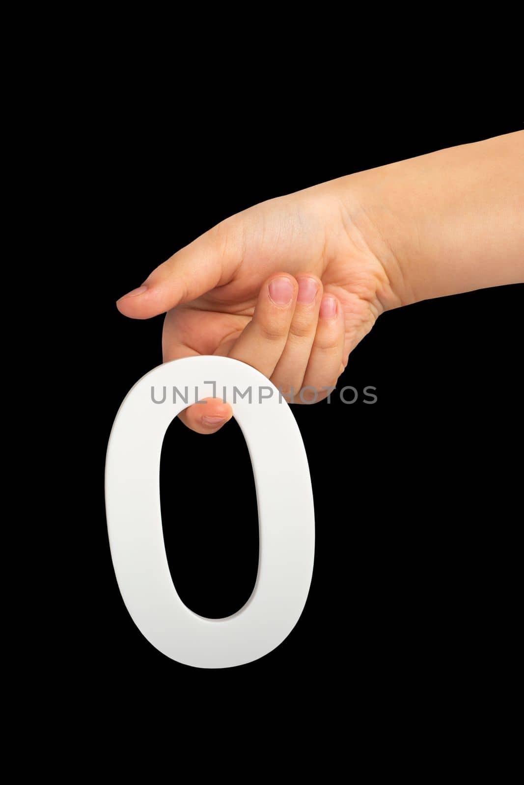 Zero in hand. The number zero is clasped in a hand isolated on a black background. Number zero white in a child's hand on a black background