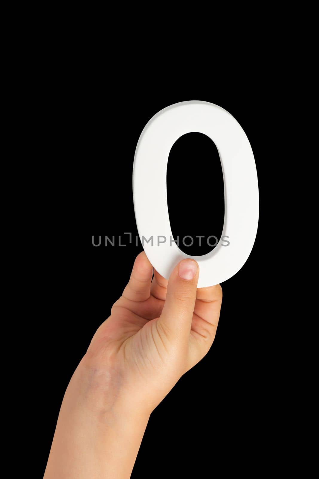 Zero in hand. The number zero is clasped in a hand isolated on a black background. Number zero white in a child's hand on a black background