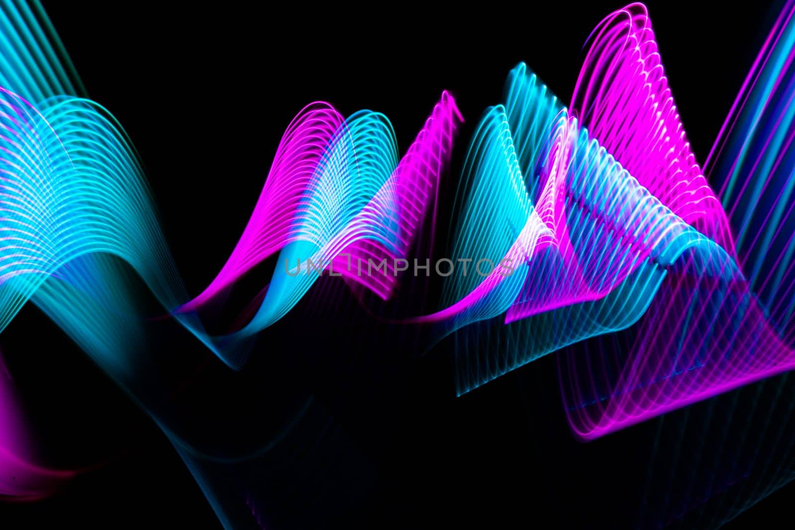 Modern light painting waves design. Technology neon blue and pink lines on black background. High quality photo