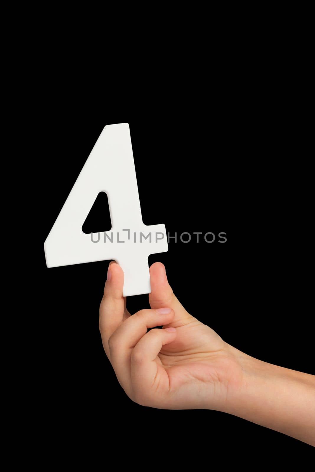 Number four in hand isolated on black background. Number four in a child's hand, holding on a black background. To be inserted into a project or design