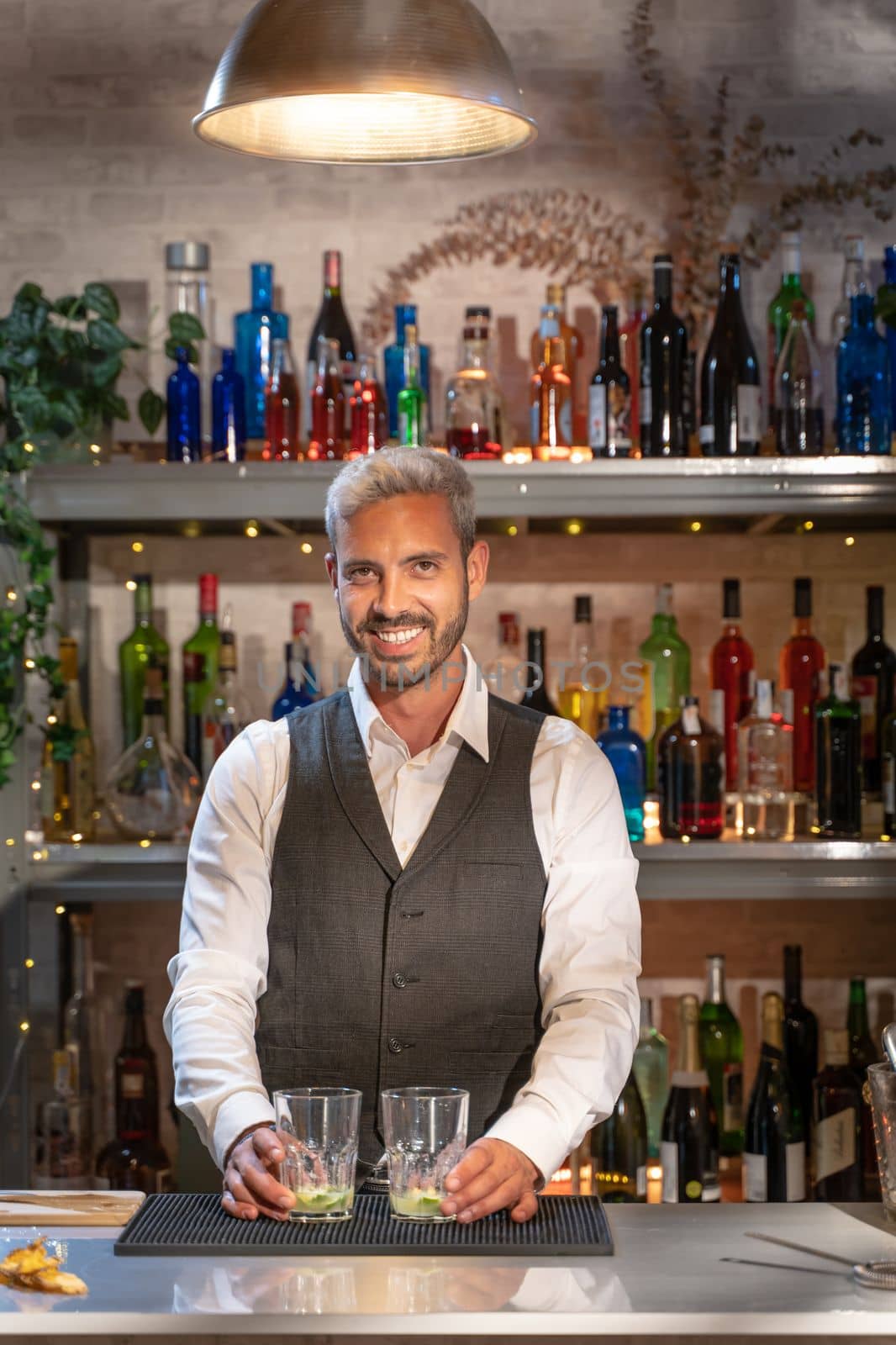 Elegant barman smiling on bar counter. by PaulCarr