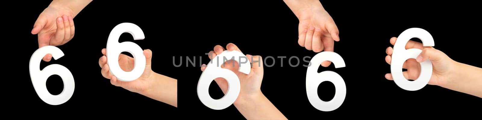 Number six in hand isolated on black background. Number 6 in a child's hand holding on a black background. A large set of hands with the number six, for inserting into a project or design