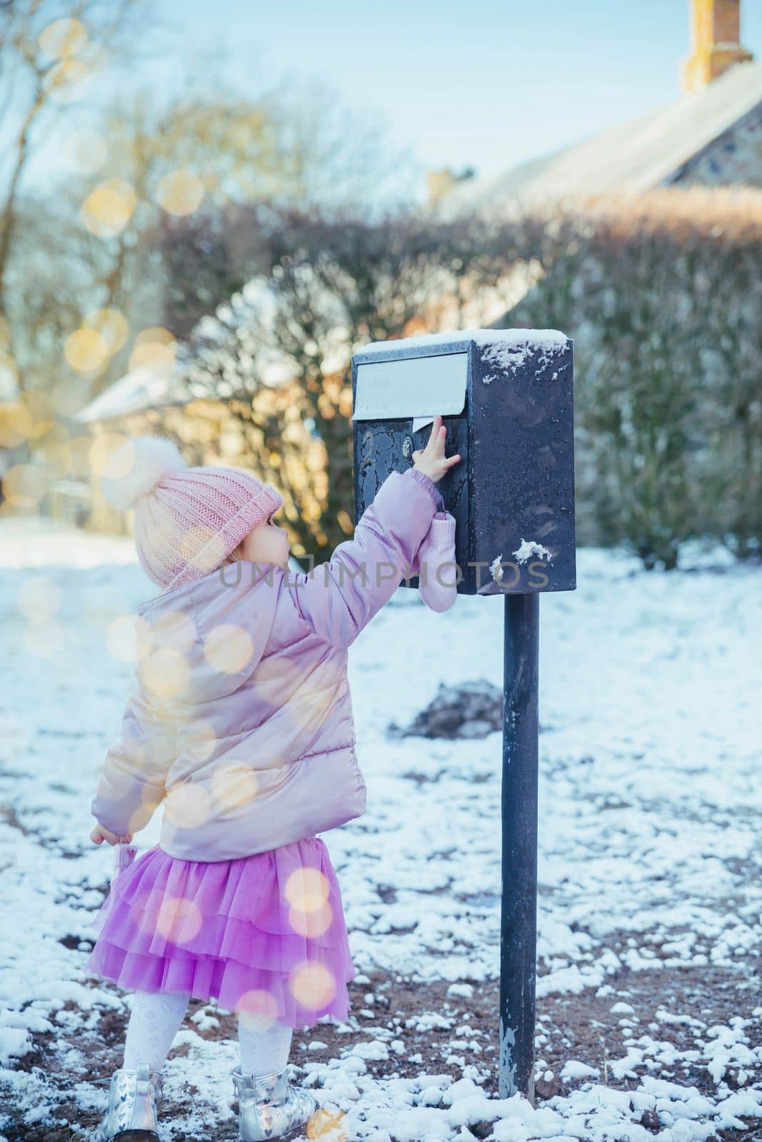 Charming baby throws a letter in the mailbox.