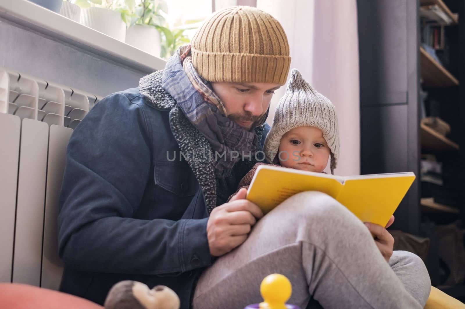 Man wearing warm clothing feeling cold checking central heating battery. Energy crisis in Europe