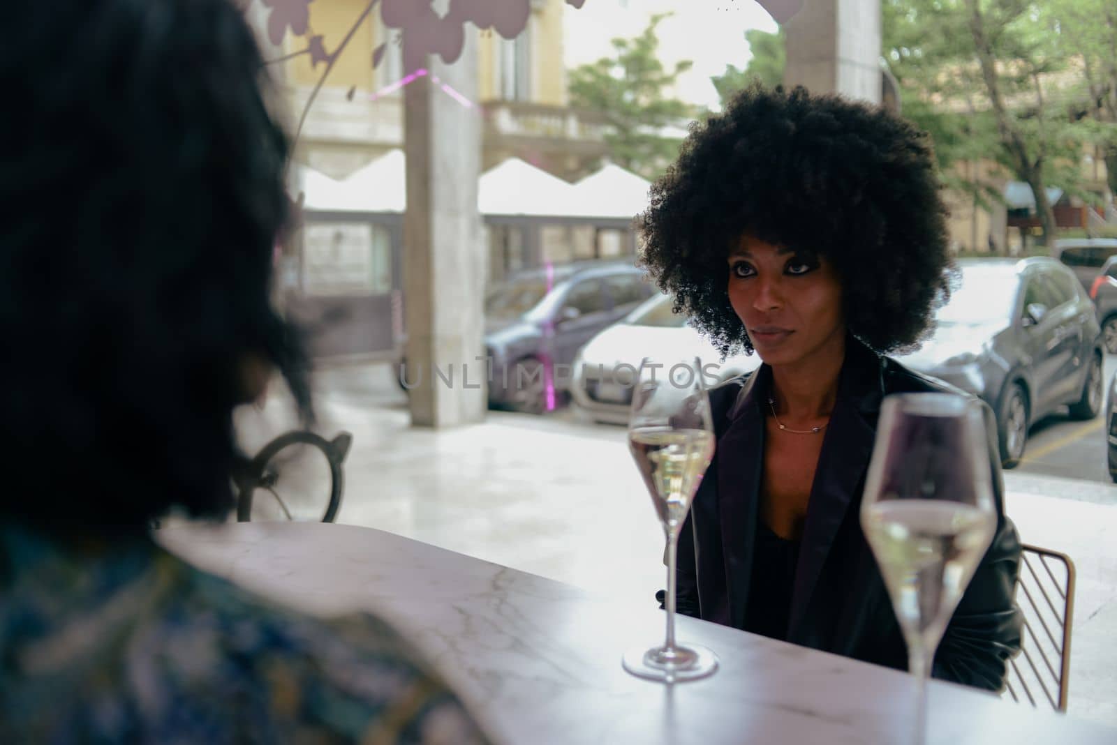 LGBT. Lesbian couple together concept. Couple of young asian woman and african woman drinking and having fun in a bar.