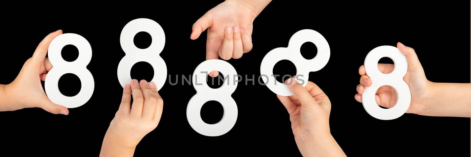Number eight in hand isolated on black background. Number 8 in a child's hand is held on a black background. A large set of hands with the number eight to insert into a project or design by SERSOL