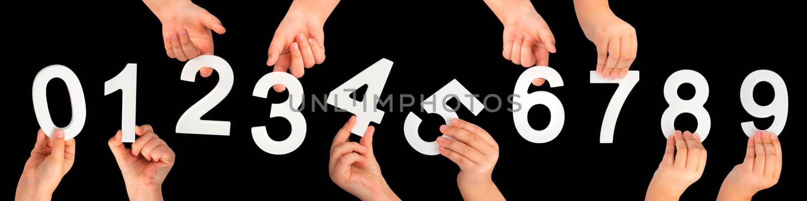 Children's hands hold numbers. A set of white numbers in hands on a black isolated background. Zero, one, two, three, four, five, six, seven, eight, nine