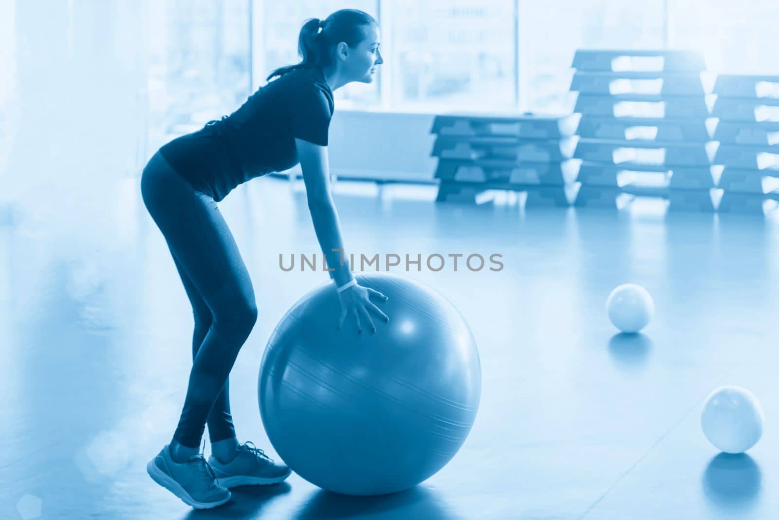 Woman at the gym doing exercises with pilates ball by Mariakray