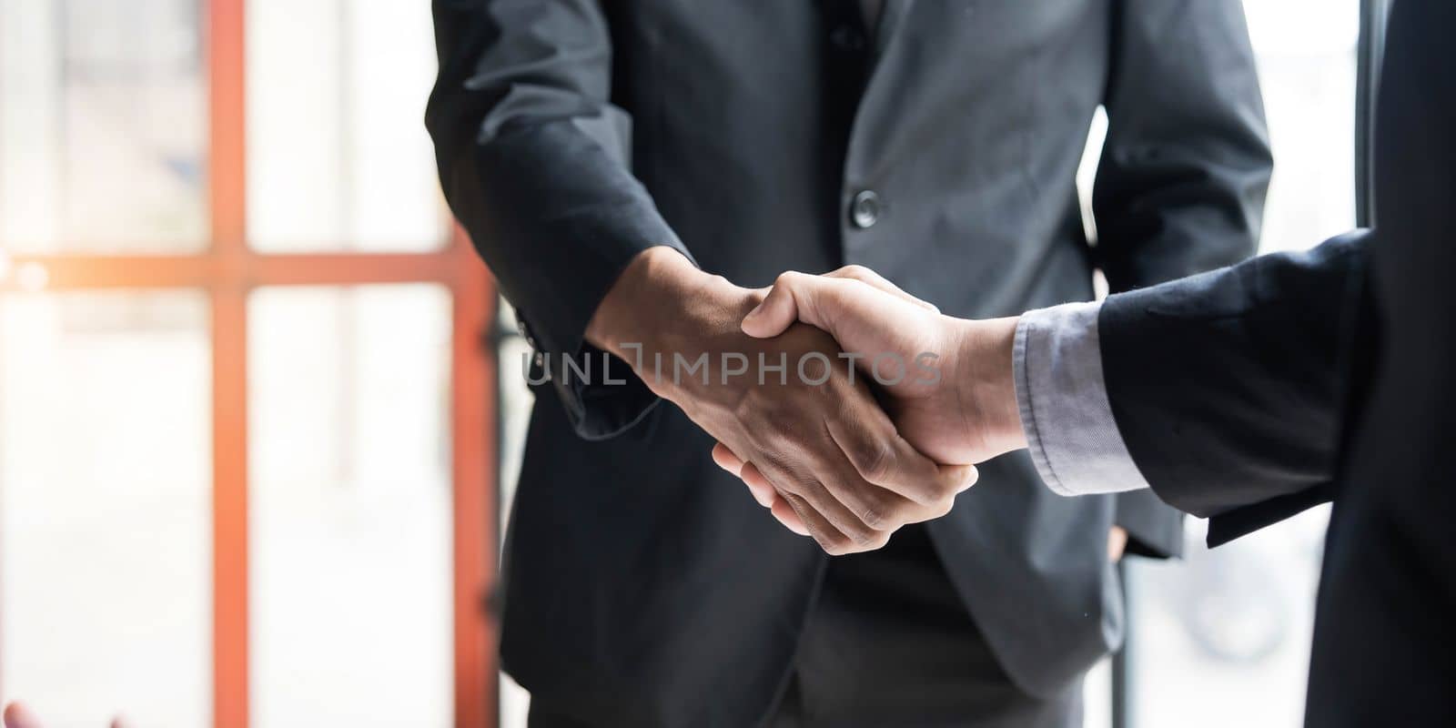 Close up of Business people shaking hands, finishing up meeting, business etiquette, congratulation, merger and acquisition concept by wichayada