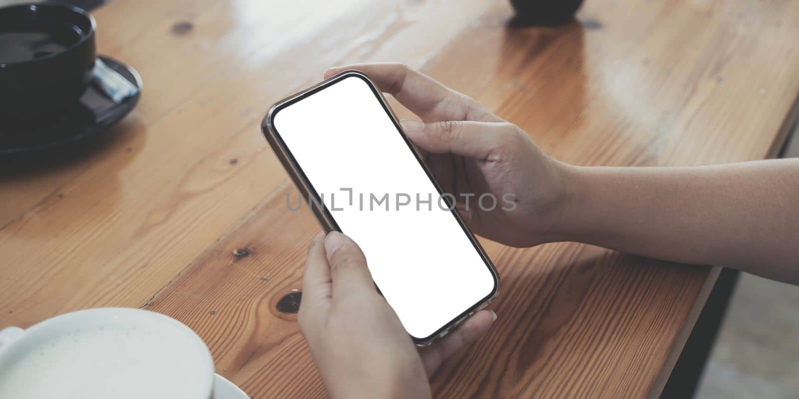 Close up of woman using cell phone,sending massages on the coffee shop.having sunbath.Phone with black screen,texting,video calls, by wichayada