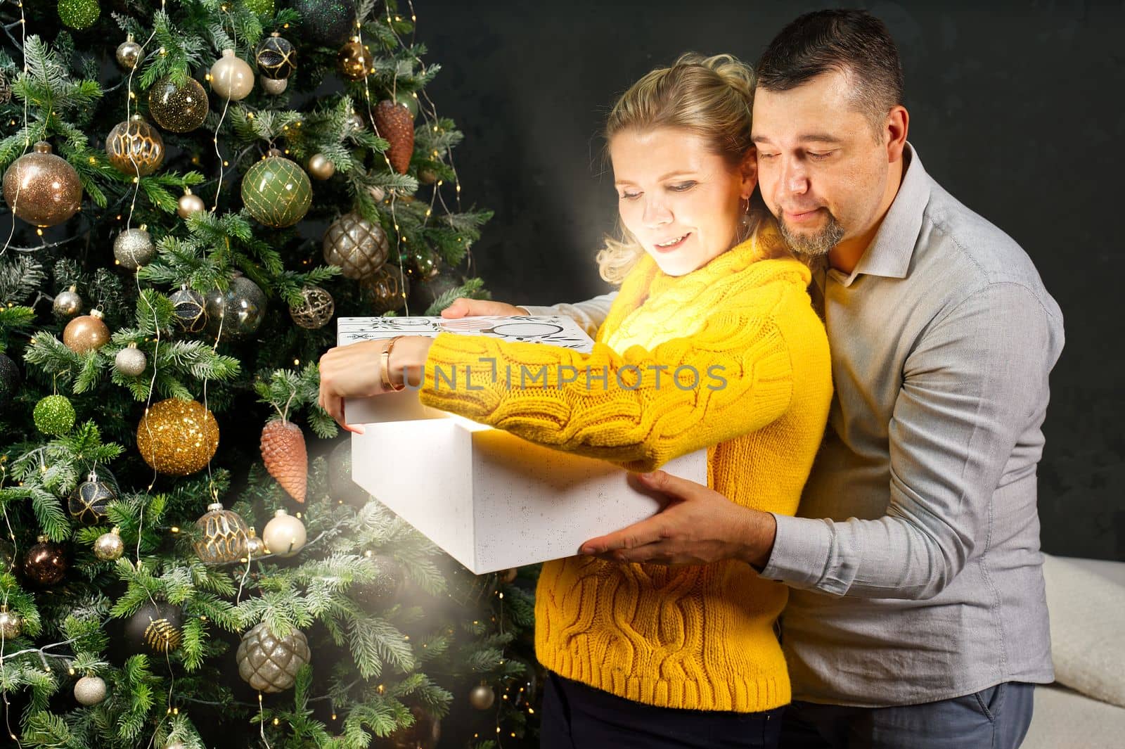 Man giving a Christmas present to his girlfriend. Opening gift box at christmas time. Christmas wonder concept by PhotoTime