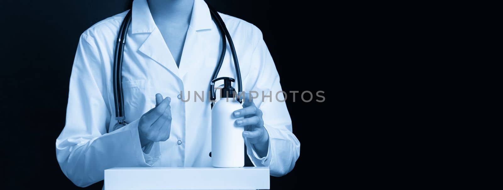 doctor applying antibacterial spray on hand on black background by Mariakray