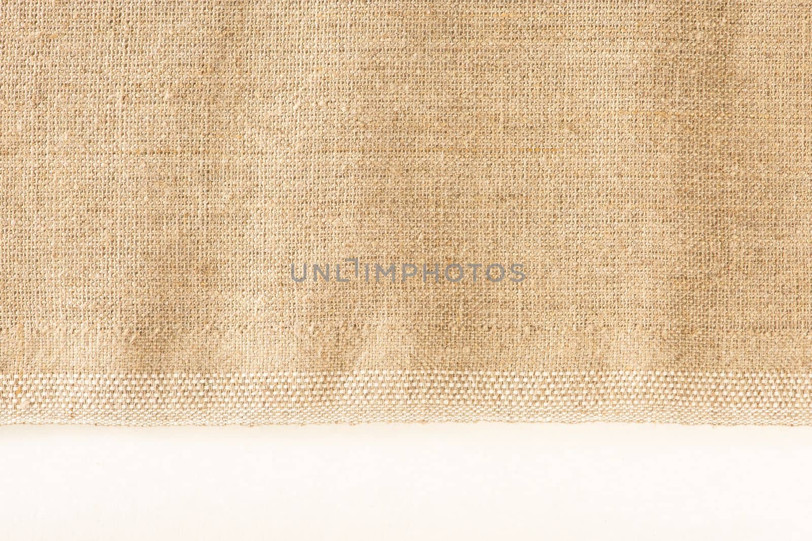 Texture of linen fabric. Natural linen fabric with a finished edge on a white background