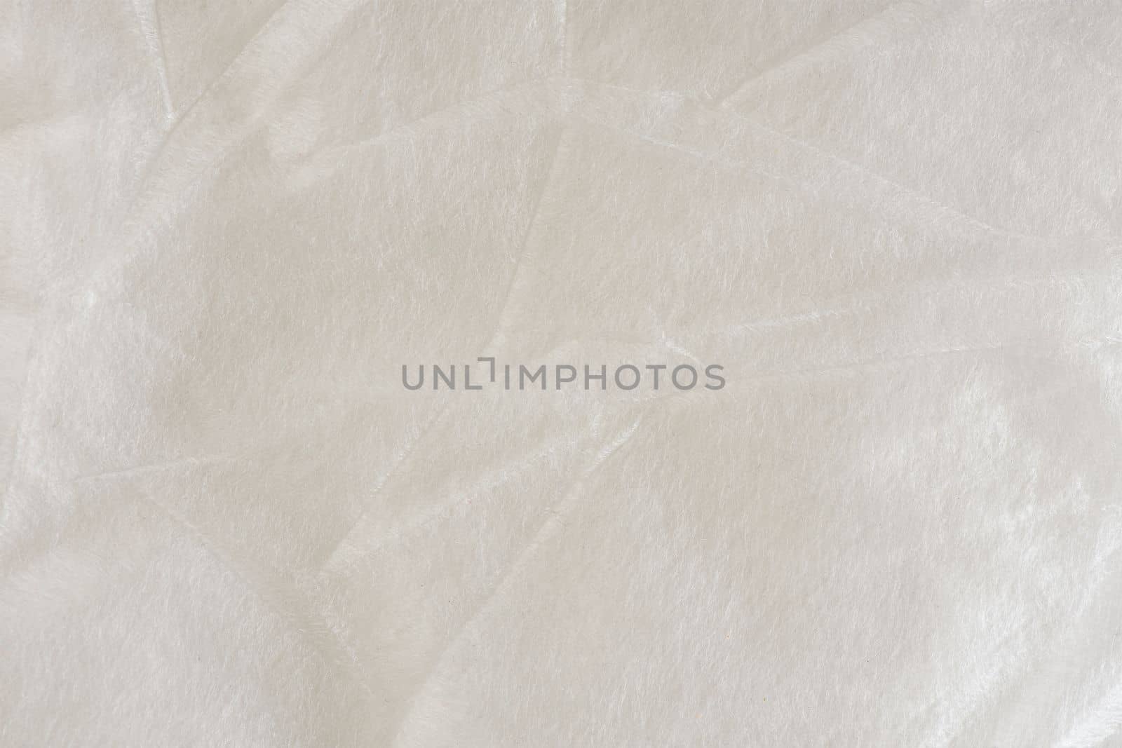 A white synthetic polyester material used as insulation in clothing or as packaging material. Texture close-up