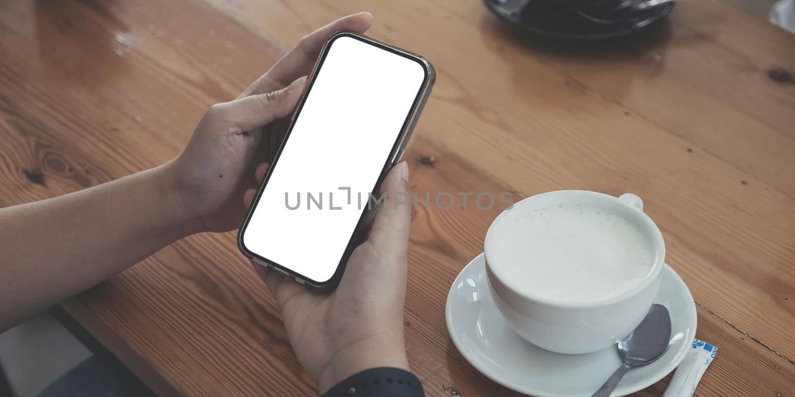 Close up of woman using cell phone,sending massages on the coffee shop.having sunbath.Phone with black screen,texting,video calls,..