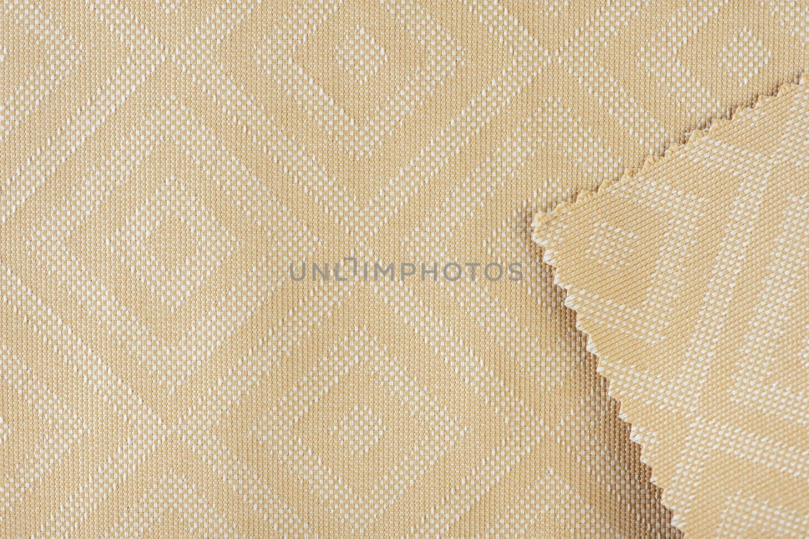 Texture of fabric for furniture upholstery in beige color with rectangular patterns or rhombuses. Texture of wear-resistant fabric for furniture production, close-up, top view