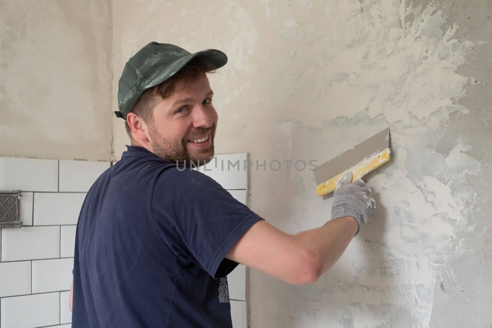 Caucasian man put plaster patching up the cracks on the wall. High quality photo