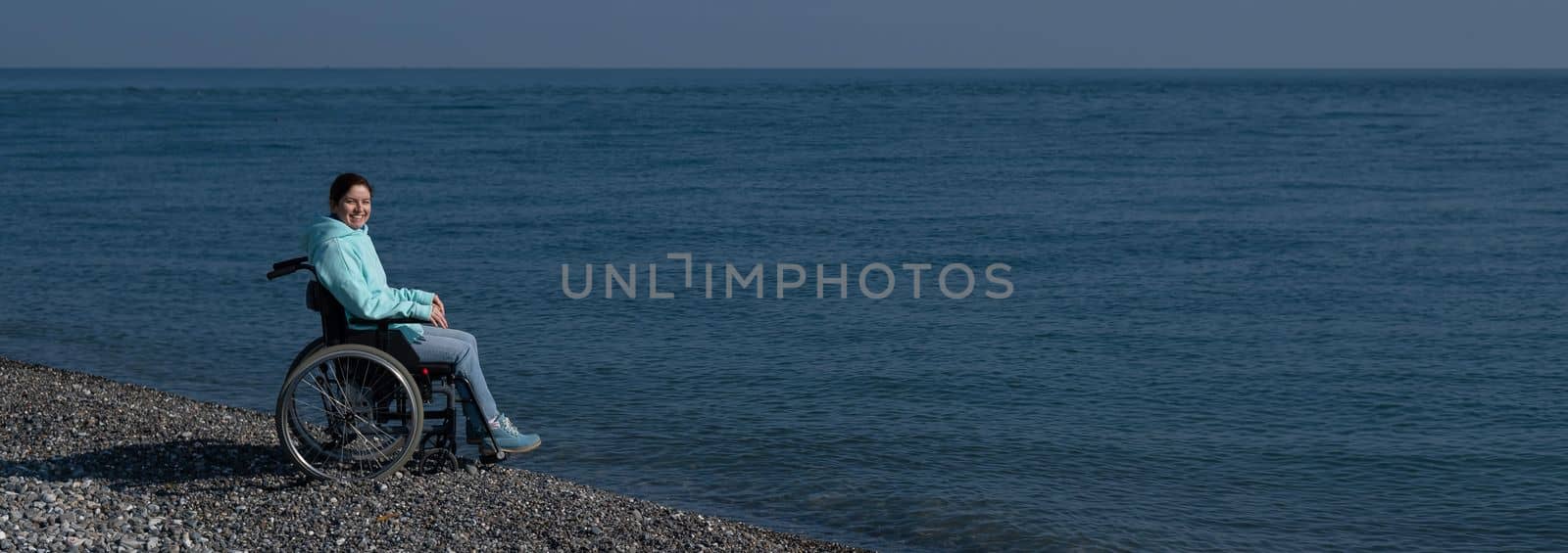 Pacified caucasian woman in a wheelchair on the seashore