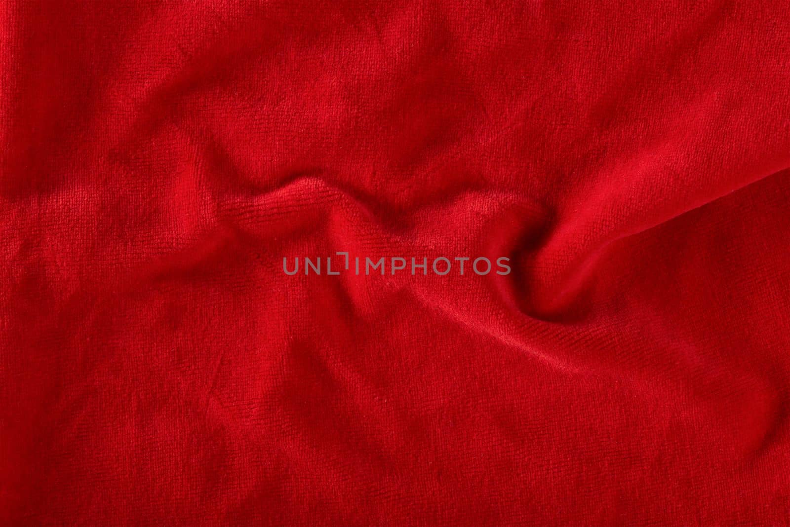 Red velvet texture for postcard or background for design. Red background for Christmas theme or Valentine's day, high quality, large format. Abstract texture of draped red velvet.