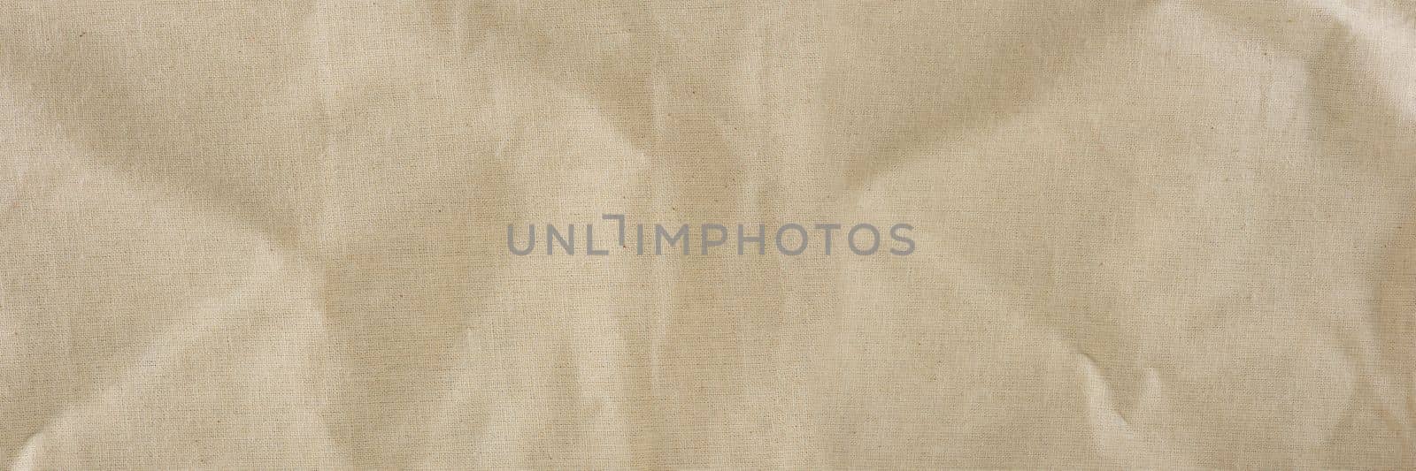 Texture of linen fabric in natural yellow color. The surface of the linen fabric as a background or banner, close-up. by SERSOL