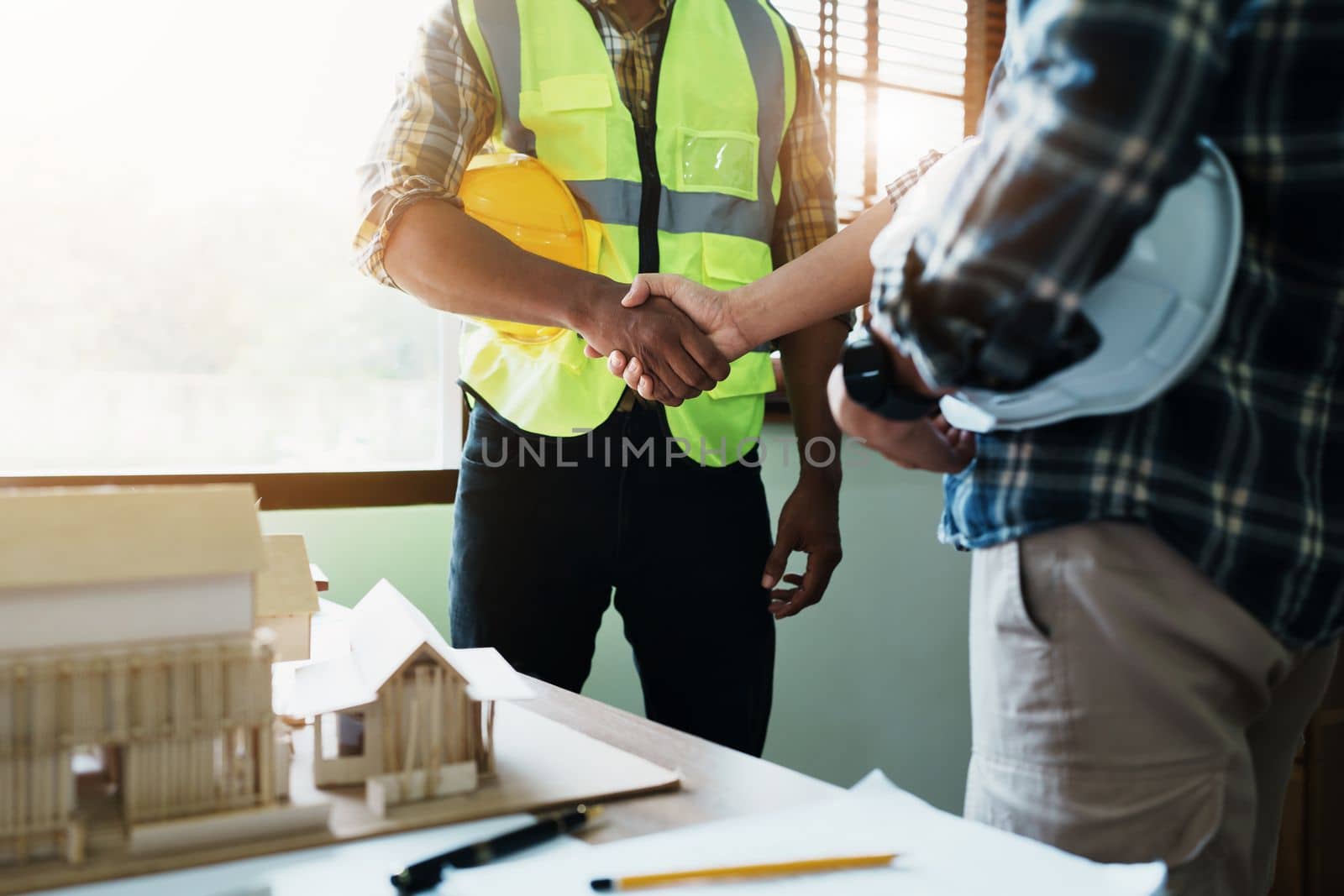 Engineers shaking hands to congratulate after success To create a building architecture successfully according to the goals that have been set.