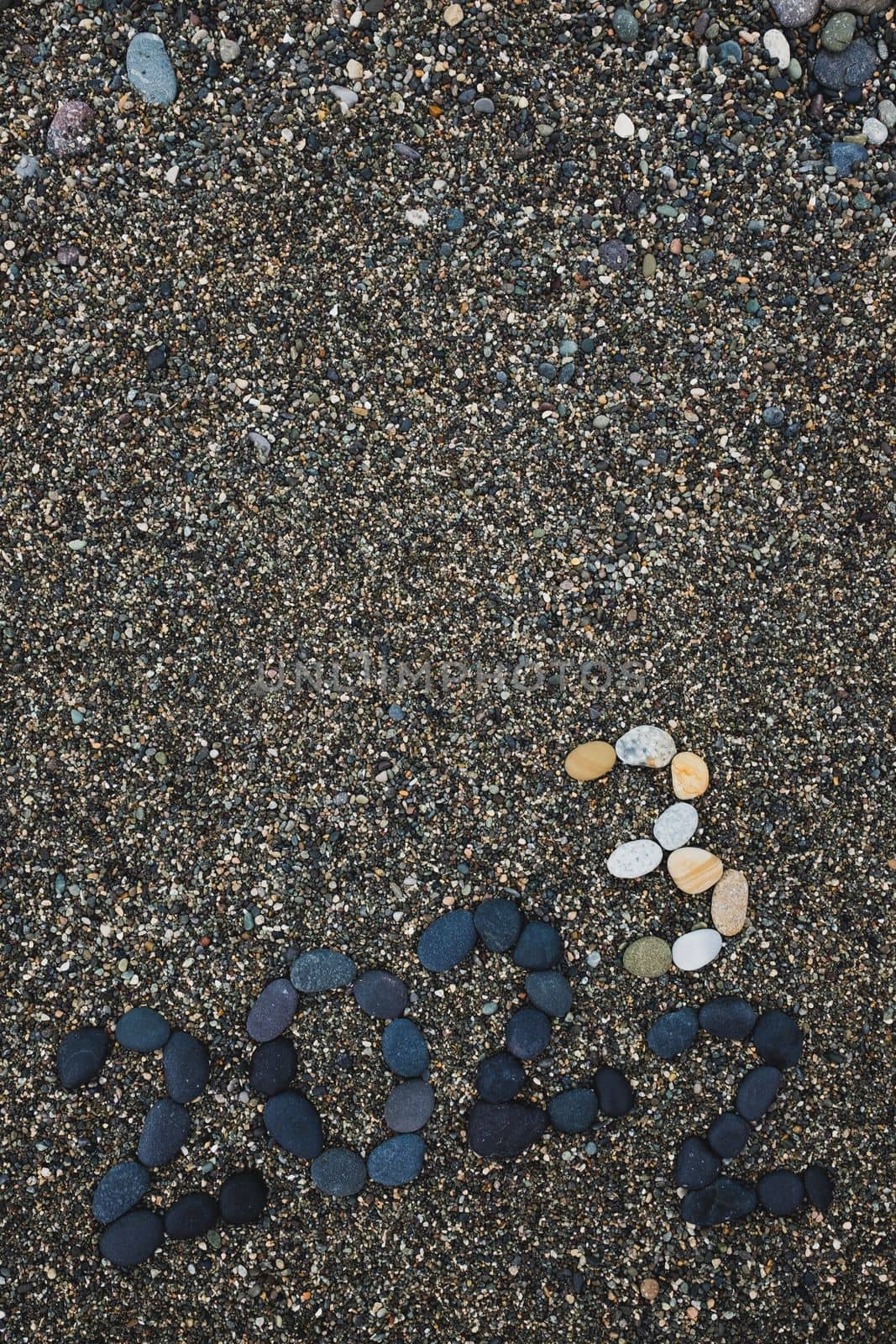Number 2023 as a New Year concept made from stones on pebble beach. Change from 2022 to 2023