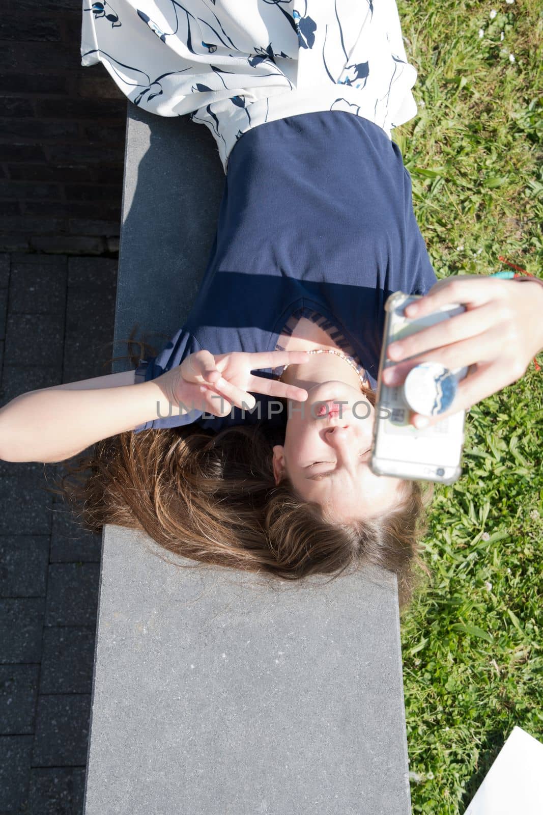 blond teenage girl takes a selfie using a mobile phone and shows a face. High quality photo