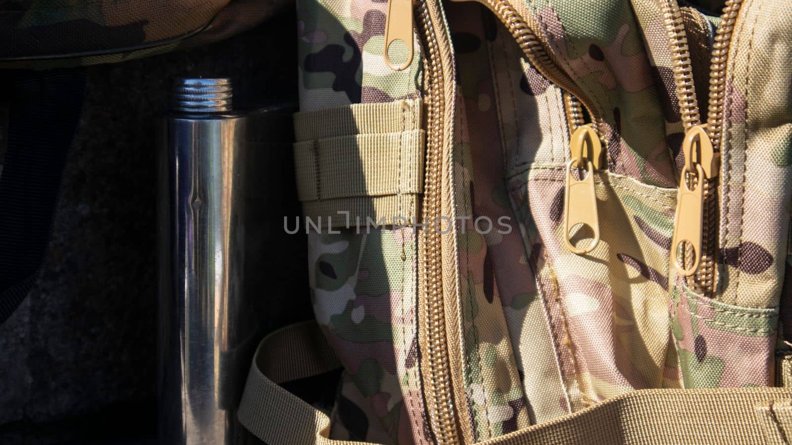 Army camouflage backpack for hiking and hunting. Brown camouflage paint for a bag, close-up photo