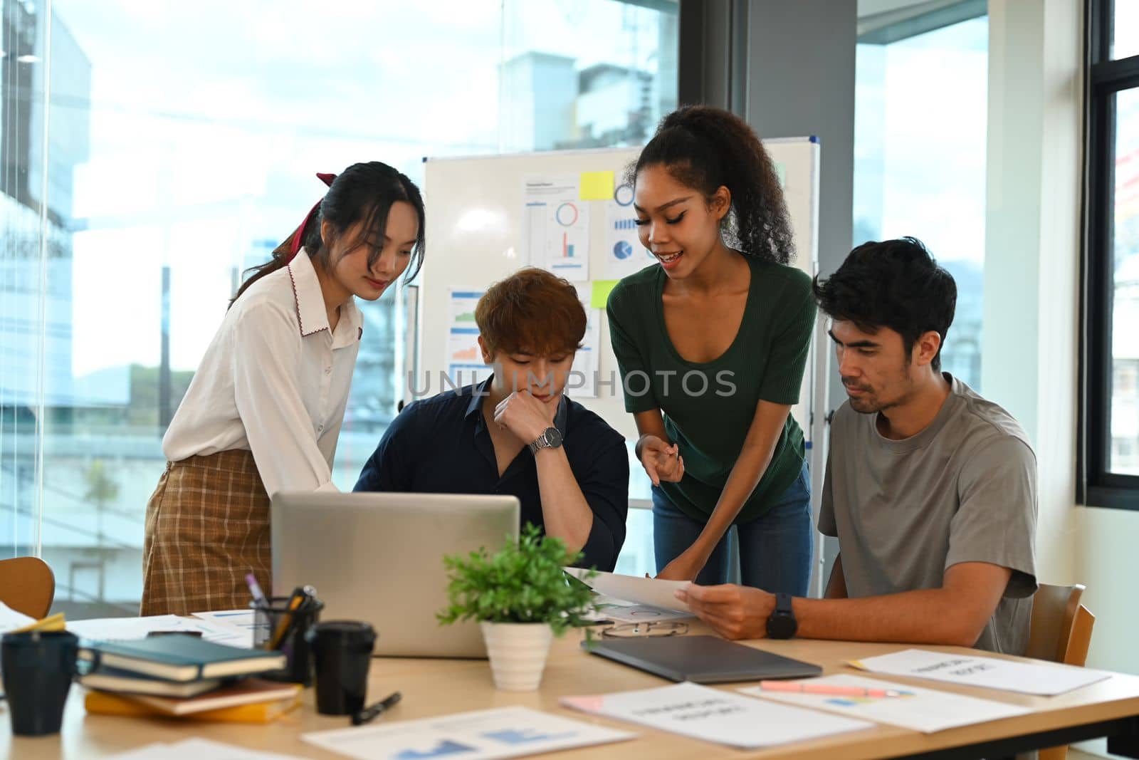 Photo of successful start up business team brainstorming for important project at office meeting.