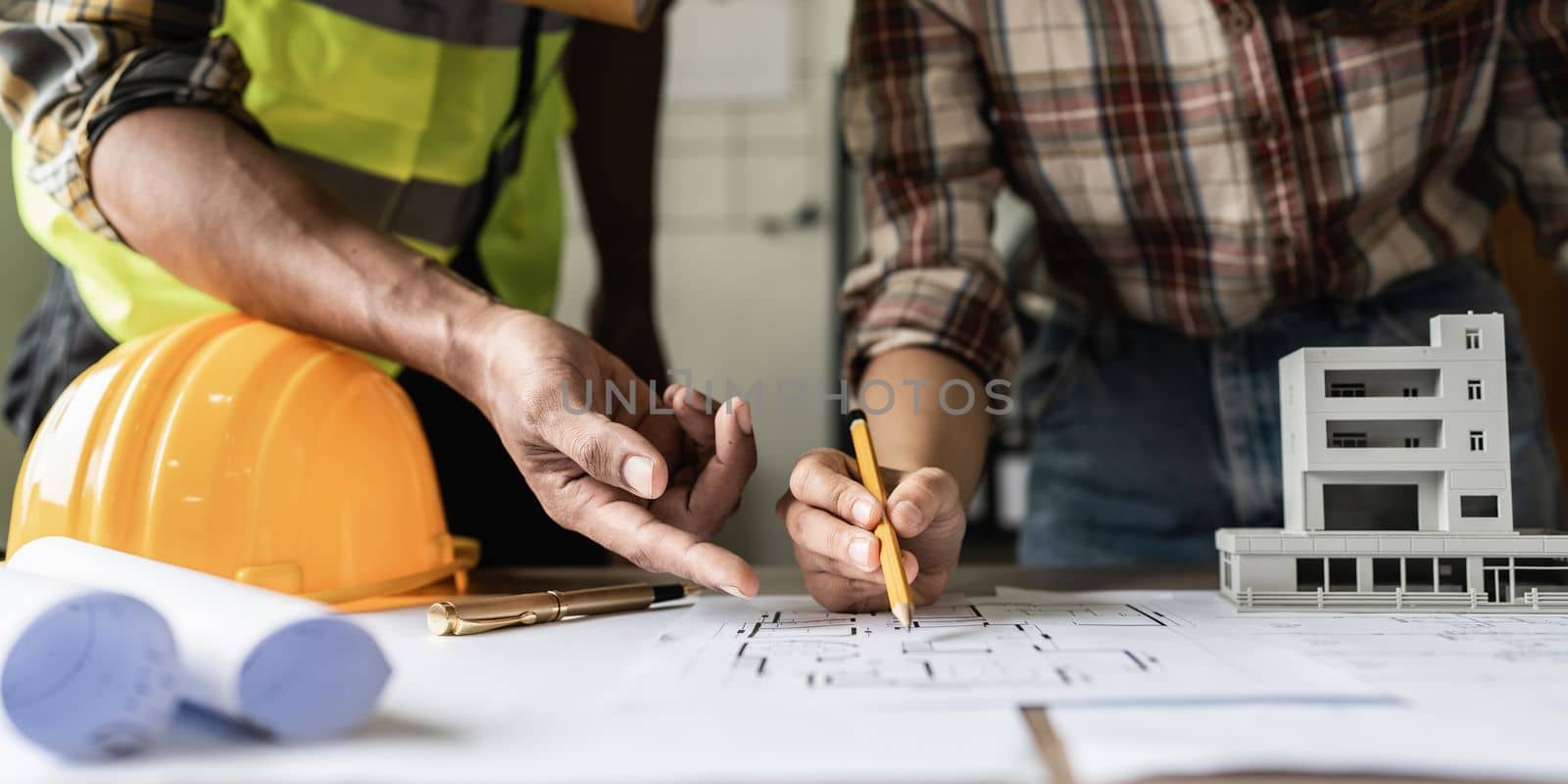 Architect man working with blueprints for architectural plan, engineer sketching a construction project concept.