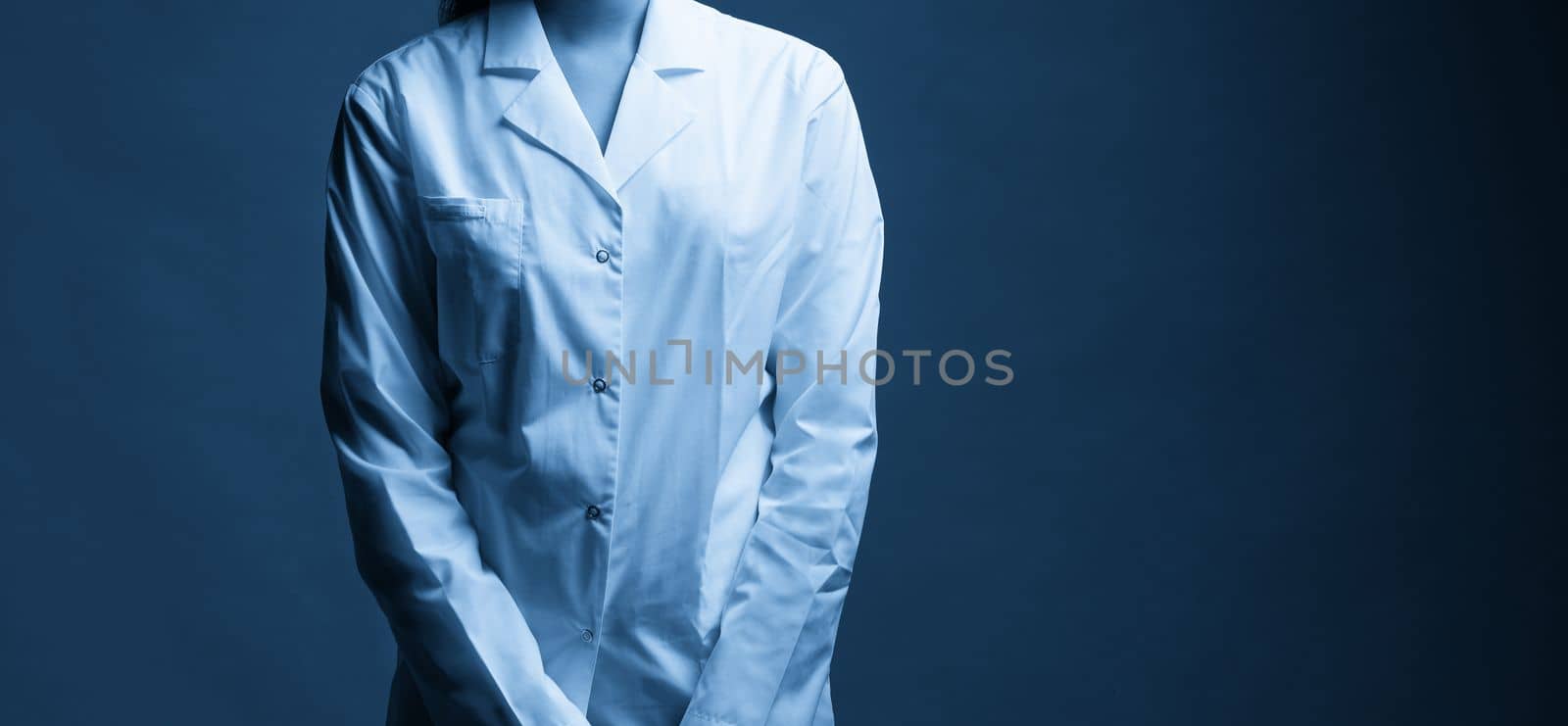 Young doctor with stethoscope against black background, studio shot with copy space by Mariakray