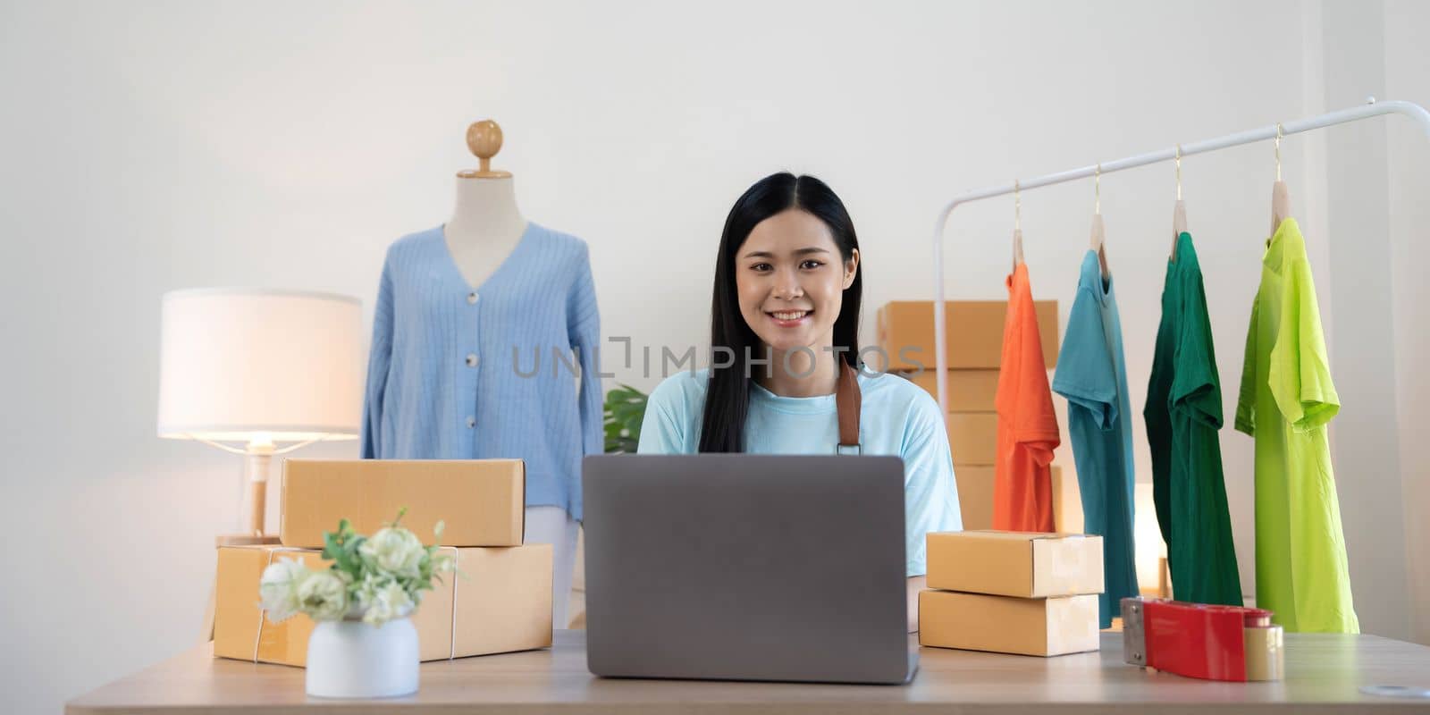 Young woman small business owner working at home office. Online marketing packaging delivery, startup SME entrepreneur or freelance woman concept.