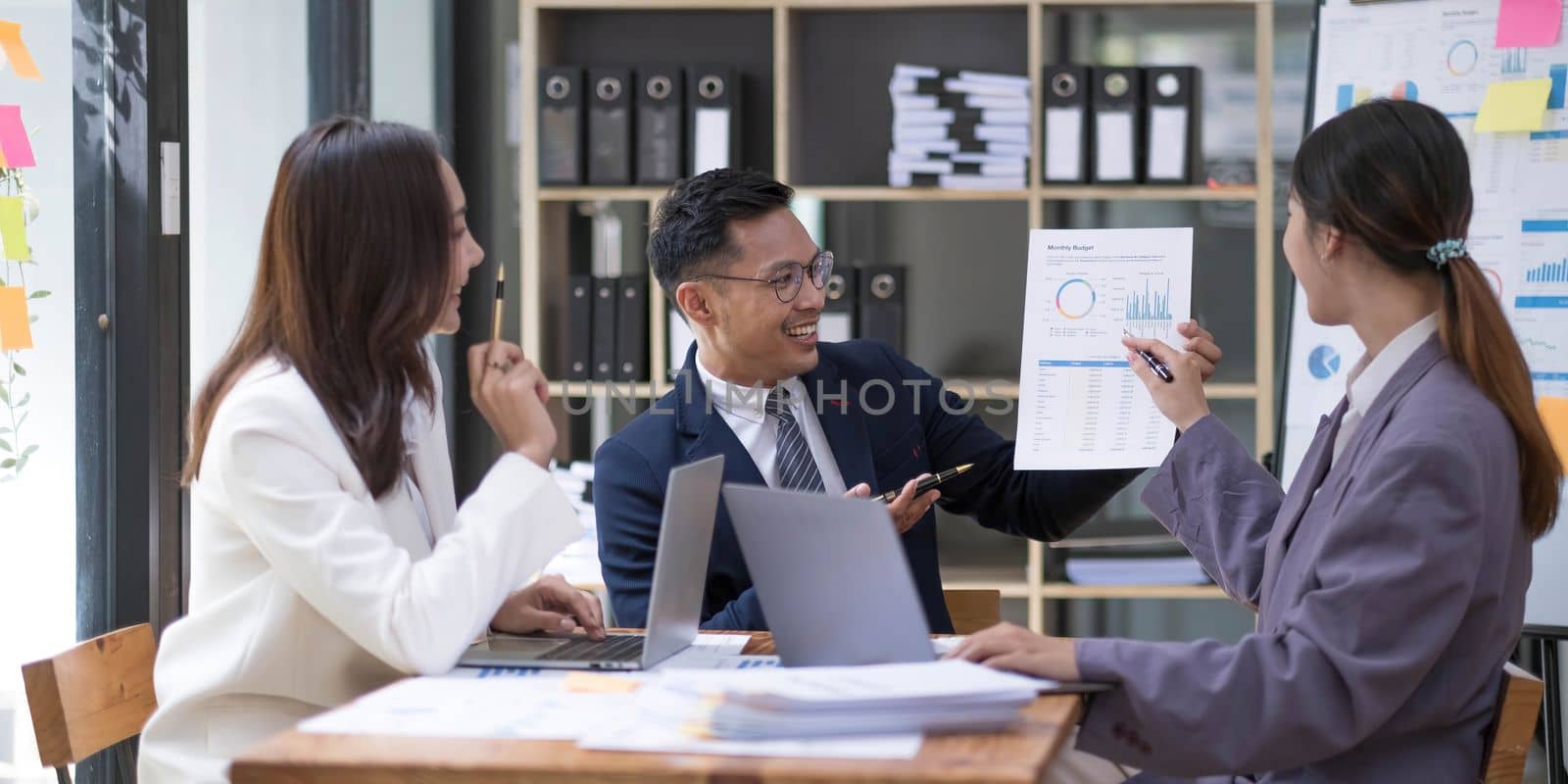 Group of young asian modern people in smart casual wear having a brainstorm meeting. Group of young asian business people discussing in the meeting. by wichayada