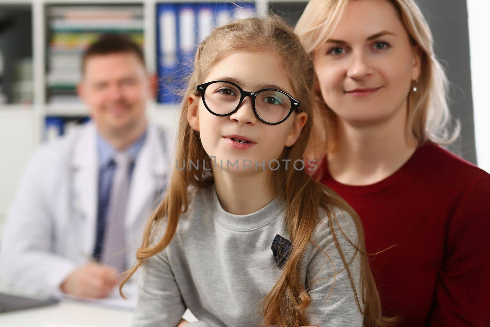 Mother and daughter at pediatrician appointment in clinic by kuprevich