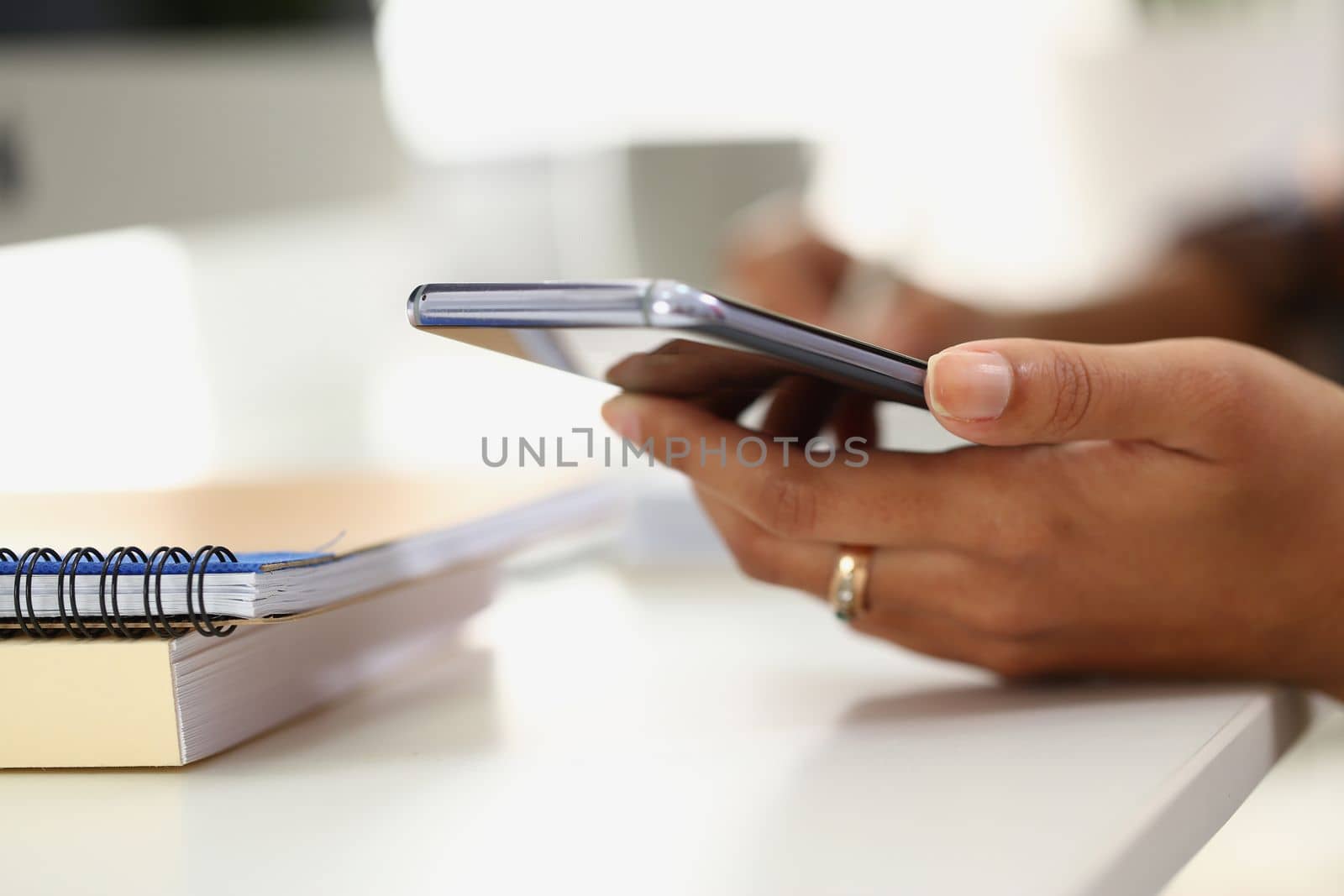 Woman writes on notebook with pen and holds smartphone. Apps for notes and reminders concept