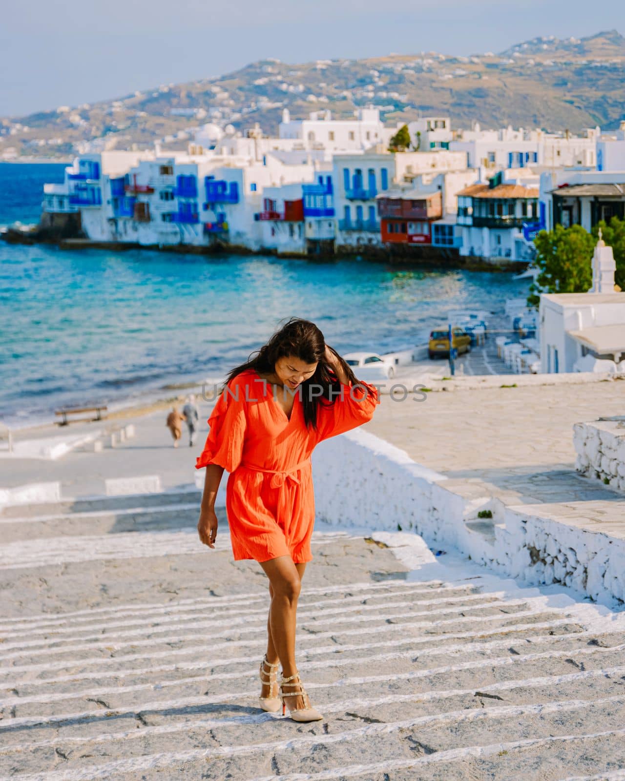 Mykonos Greece, Young woman in dress at the Streets of old town Mikonos during vacation in Greece by fokkebok