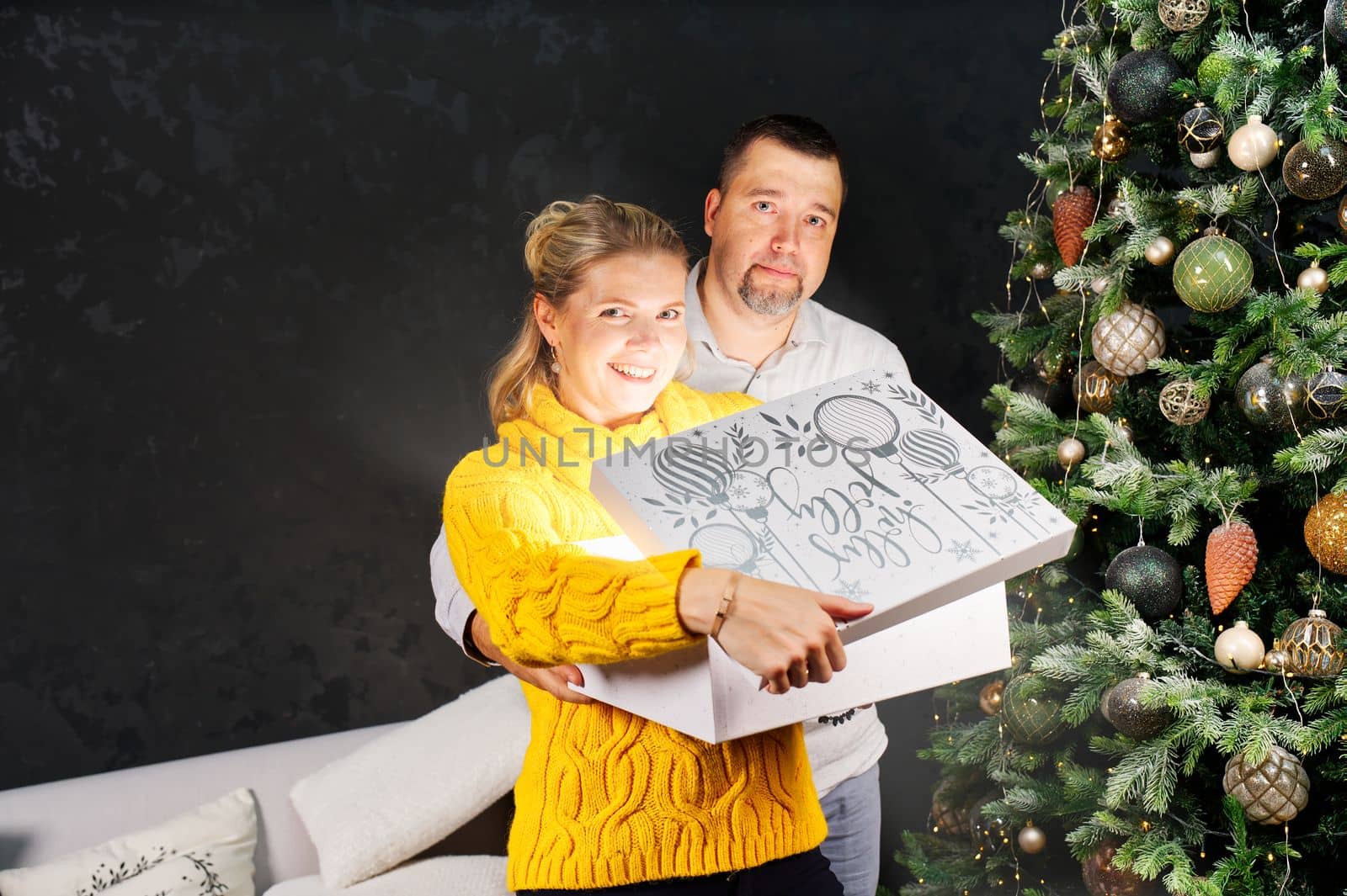 Man giving a Christmas present to his girlfriend. Opening gift box at christmas time. Christmas wonder concept by PhotoTime