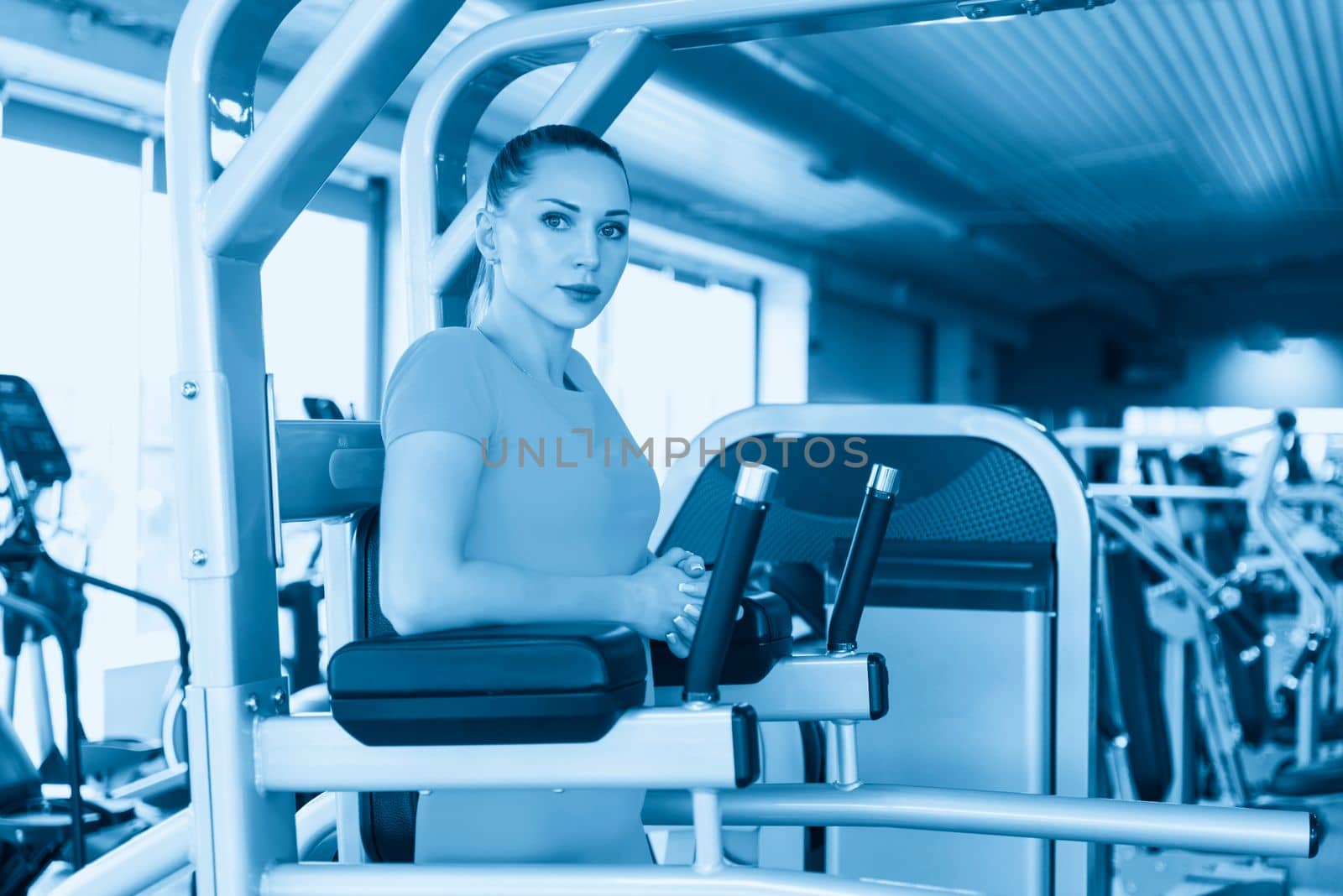 Training abs and raising legs. Young pretty muscular woman doing Fitness exercise. Concept of health and sport lifestyle.