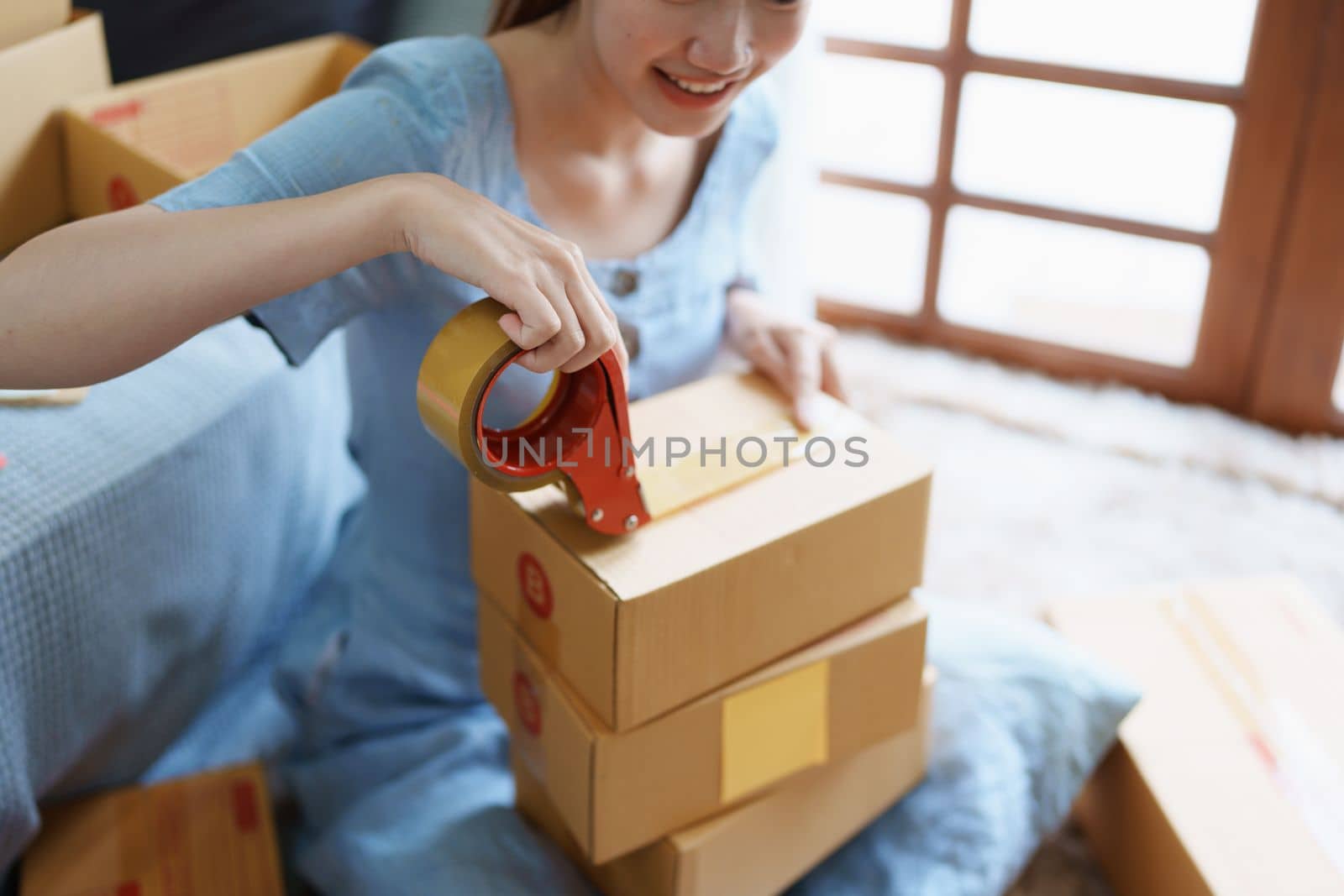 Starting small business entrepreneur of independent Asian female online seller packing products to send to customers and SME delivery concept.