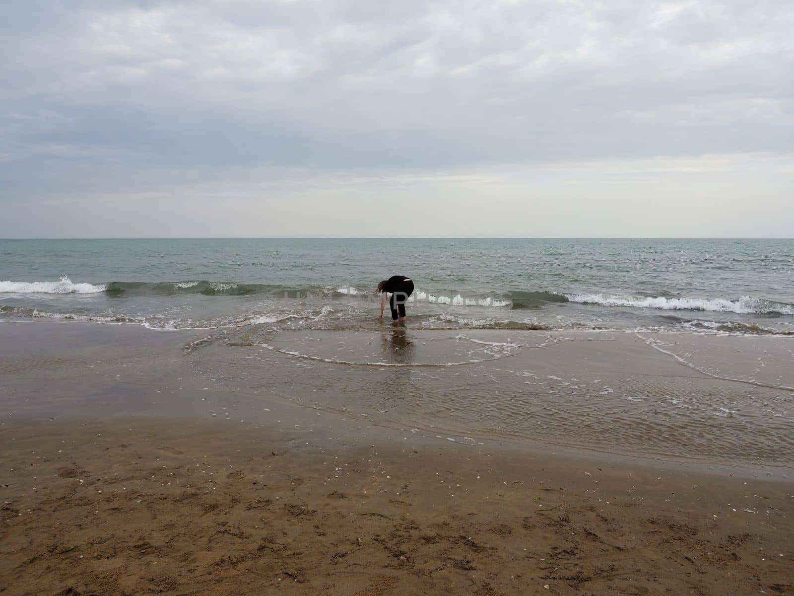 womanpicking stones at the beach