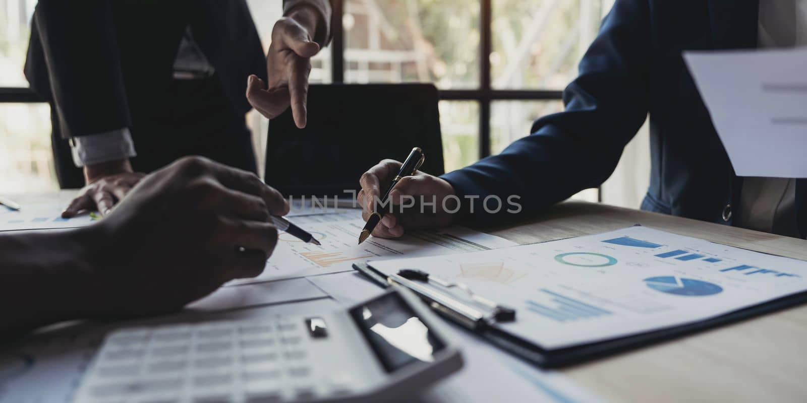 Business People Meeting using laptop computer,calculator,notebook,stock market chart paper for analysis Plans to improve quality next month. Conference Discussion Corporate Concept. by wichayada