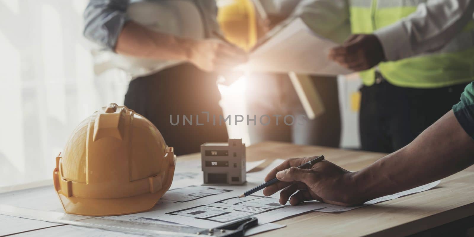 Civil engineer teams meeting working together wear worker helmets hardhat on construction site in modern city. Foreman industry project manager engineer teamwork. Asian industry professional team...