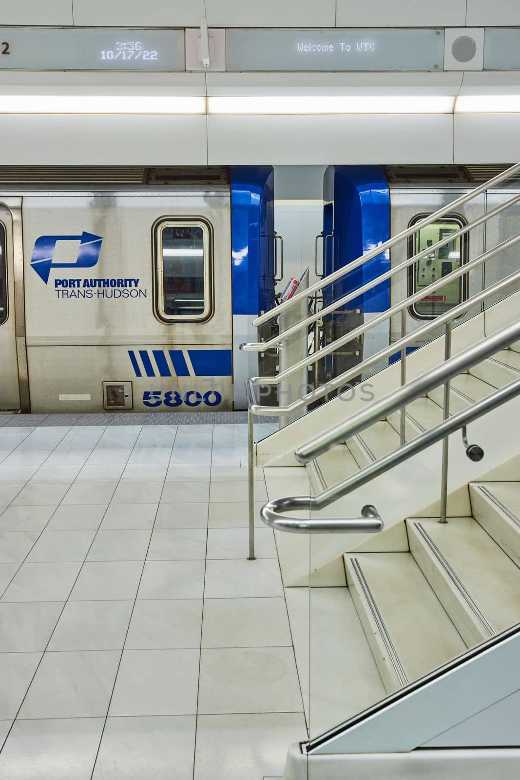 Image of Clean modern subway train stairs up from side and Port Authority Trans-Hudson blue train waiting
