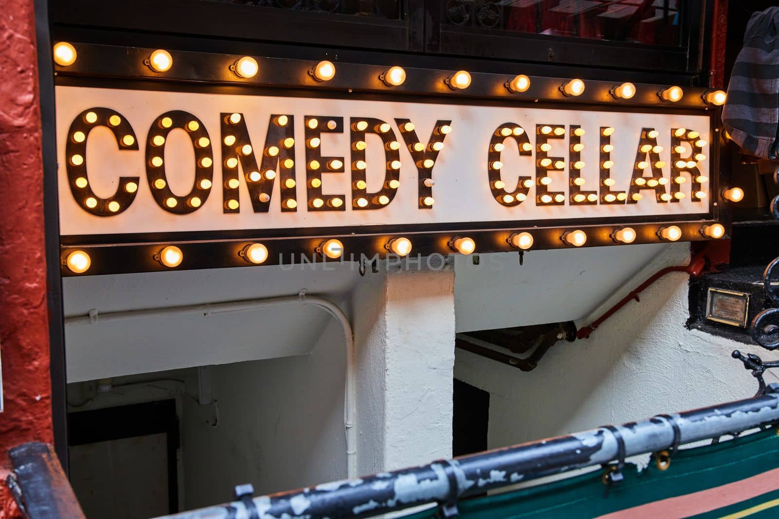 Image of Comedy Cellar neon bulb lights sign going into basement in New York City