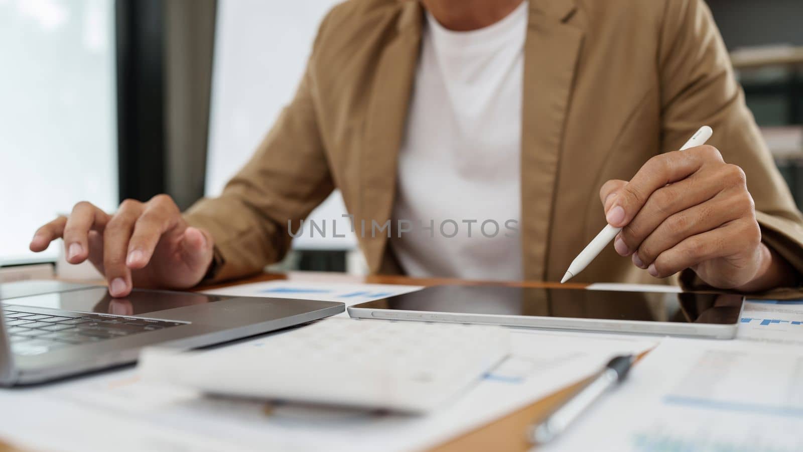 Asian businessman checking information while working with satisfaction on his laptop.